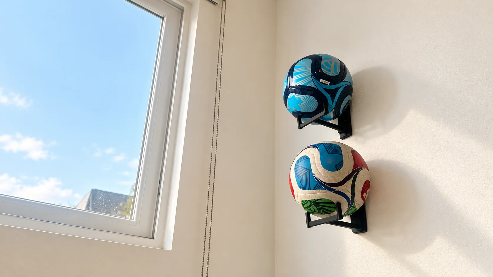 Dos balones de fútbol en sus porta balón HAIQUE, junto a una ventana